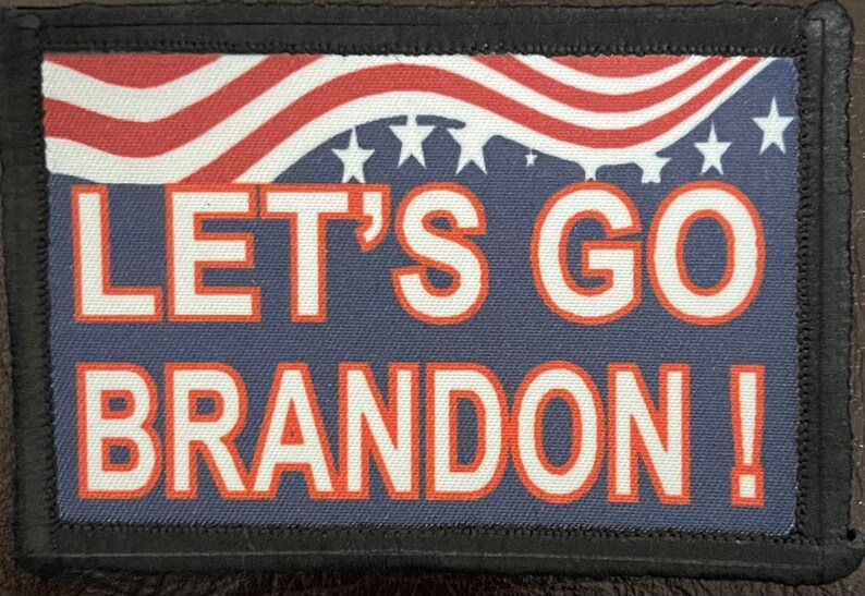 May include: A blue and red American flag patch with white stars and the text "LET'S GO BRANDON!" in white letters with a red outline.