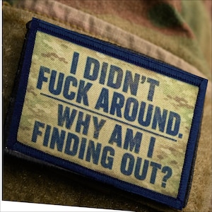 May include: A rectangular patch with a camouflage background and a dark blue border. The patch features the text "I DIDN'T FUCK AROUND. WHY AM I FINDING OUT?" in bold, blue capital letters.