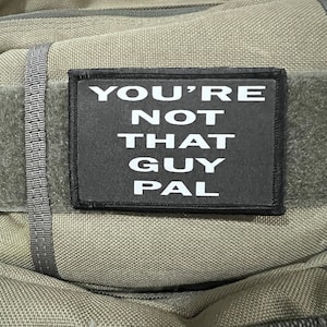 以下が含まれることがあります： 緑色の布地に、「YOU'RE NOT THAT GUY PAL」という白い文字が書かれた黒いパッチ