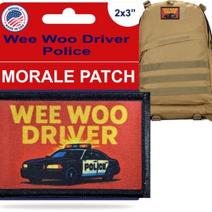 May include: A rectangular morale patch with the text "WEE WOO DRIVER" above a police car graphic. The patch is 2x3 inches and has a black border. A tan backpack is in the background, with a smaller patch on it.