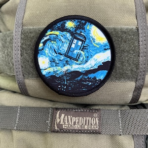 May include: A green Maxpedition Hard-Use Gear backpack with a round patch featuring a blue and white TARDIS flying through a starry night sky.