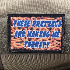 Könnte beinhalten: Ein schwarz-weißes Patch mit einem Bild von Brezeln und dem Text "THESE PRETZELS ARE MAKING ME THIRSTY" in Blau.