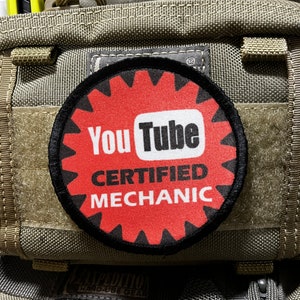 May include: A black and red round patch with the YouTube logo and the text "Certified Mechanic".
