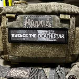 May include: A green Maxpedition Hard-Use Gear bag with a black patch that says "AVenge The Death Star" on it.