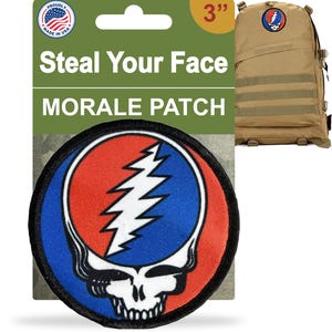May include: A round, embroidered morale patch with a skull and lightning bolt design, measuring 3 inches. The patch features red, blue, and white colors. The packaging reads "Steal Your Face MORALE PATCH" and "Made in USA". A tan backpack is also shown.