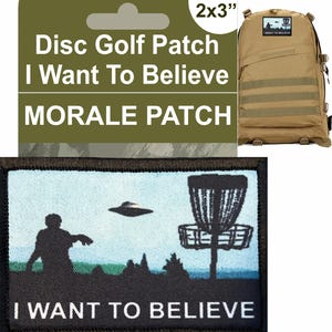 Pode incluir: Um remendo de frisbee preto e branco com uma silhueta de uma pessoa lançando um disco para uma cesta. O remendo tem o texto "I Want To Believe" em letras brancas sobre um fundo preto. O remendo mede 2 polegadas por 3 polegadas.
