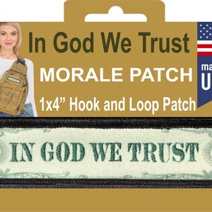 以下が含まれることがあります： 「IN GOD WE TRUST」の文字と黒い縁取りが施された長方形のモラルパッチ。 パッチのサイズは約2.5 x 10 cmで、面ファスナーの裏地が付いています。 画像には「MORALE PATCH」と「made in USA」の文字も含まれています。