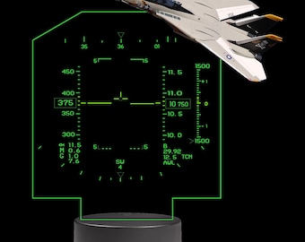May include: A decorative light featuring a fighter jet model positioned above a flat, transparent acrylic panel etched with a green digital heads-up display interface. The display shows various flight data metrics, numbers, and symbols.