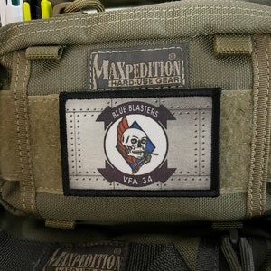 May include: A green Maxpedition Hard-Use Gear bag with a black and white patch that says "Blue Blasters VFA-34".