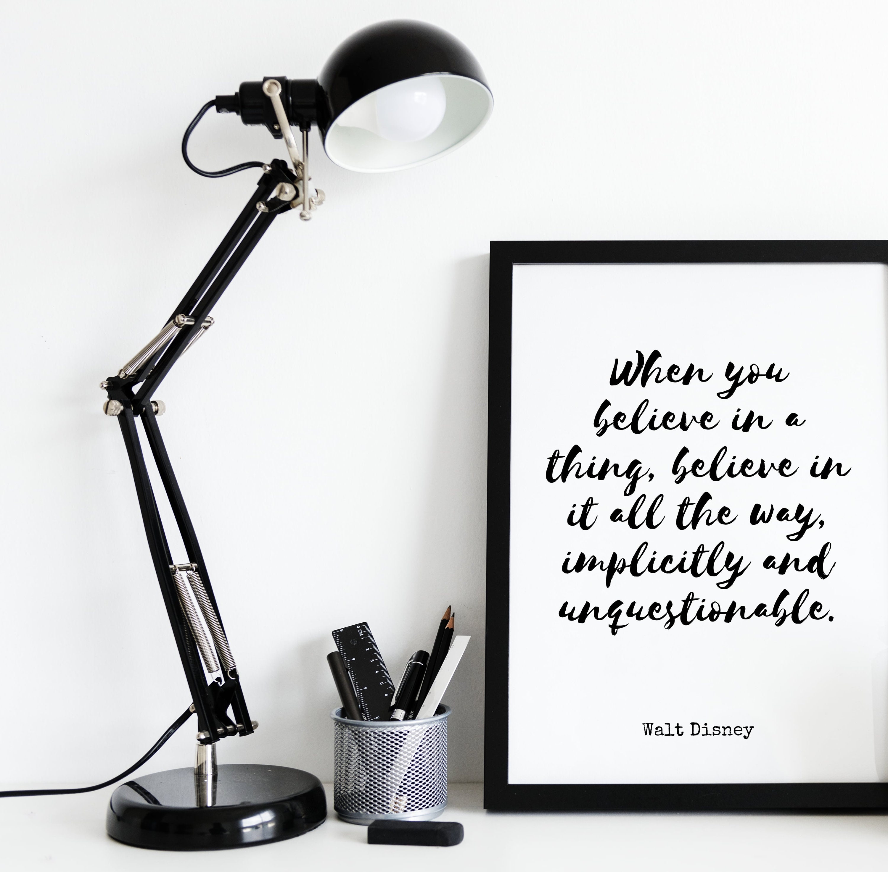 framed disney quote on desk with lamp 