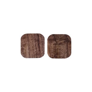 May include: Two square wooden coasters with a dark brown wood grain pattern.