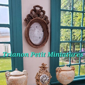 Miniature French Oval Mirrors with an antique wood finish topped by French Ribbon Motif