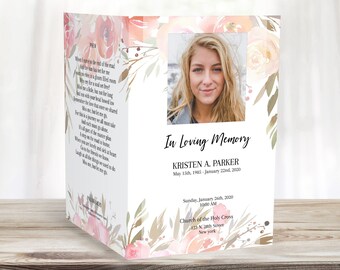 Könnte beinhalten: Eine Traueranzeige mit einem Blumendesign und einem Foto einer Frau. Der Text lautet: "In liebevoller Erinnerung Kristen A. Parker 15. Mai 1985 - 22. Januar 2000 Sonntag, 26. Januar 2000 10:00 Uhr Kirche des Heiligen Kreuzes 123 N. 28th Street New York"