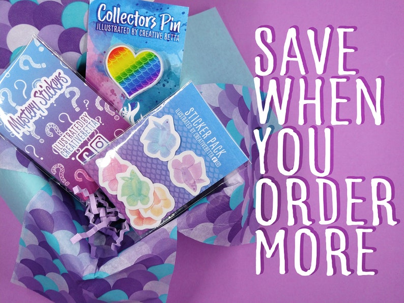 May include: A selection of stickers, a collector's pin, and a mystery sticker pack are presented in a decorative box. The pin is heart-shaped with a rainbow design. The text "SAVE WHEN YOU ORDER MORE" is visible.