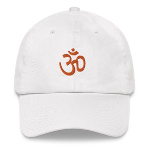 Op de afbeelding: Witte baseballpet met een oranje geborduurd Om-symbool.