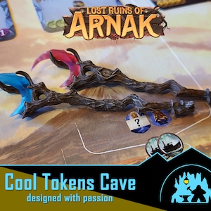 Puede incluir: Dos bastones de madera con alas translúcidas azules y rojas. Los bastones son del juego de mesa Lost Ruins of Arnak. La imagen es de Cool Tokens Cave, una empresa que diseña fichas de juego.