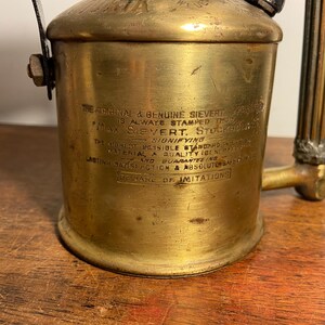 Pode incluir: Um ma&ccedil;arico de solda Sievert vintage de lat&atilde;o com uma pega longa e canelada. O ma&ccedil;arico tem um r&oacute;tulo que diz "The Original & Genuine Sievert" e "Beware of Imitations".