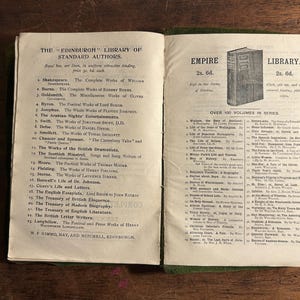 Pode incluir: Livro aberto com texto de "The Edinburgh Library of Standard Authors" e "Empire Library". As p&aacute;ginas est&atilde;o envelhecidas, com uma lombada verde. O texto lista autores e t&iacute;tulos de livros.