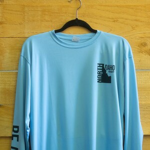 North Idaho Nomads XL Light Blue long-sleeve performance shirt with logo on chest