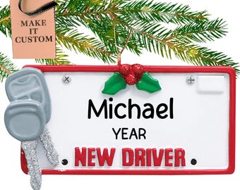 Può includere: Addobbo natalizio rosso e bianco a forma di targa con un ramo di agrifoglio, una chiave d'auto argentata e il testo "Michael YEAR NEW DRIVER".
