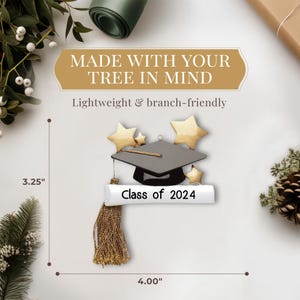 May include: A graduation cap ornament with a diploma scroll and gold stars. The ornament is 3.25 inches tall and 4 inches wide. The text on the diploma scroll reads "Class of 2024".