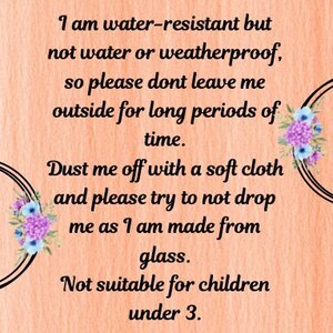 May include: A peach-colored background with black circular designs and floral accents. The text reads: "I am water-resistant but not water or weatherproof...Dust me off with a soft cloth...Not suitable for children under 3."