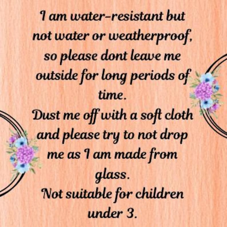 May include: A peach-colored background with black circular designs and floral accents. The text reads: "I am water-resistant but not water or weatherproof...Dust me off with a soft cloth...Not suitable for children under 3."