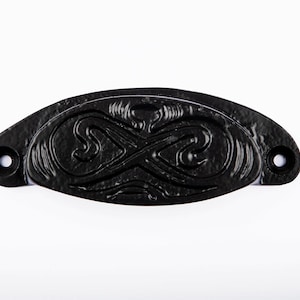 May include: Black metal cabinet pull with an ornate infinity symbol design.