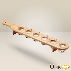Può includere: Un porta bicchieri da shot in legno con manico. Il porta bicchieri ha sei bicchieri da shot in vetro trasparente.