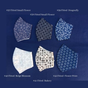 May include: Assortment of fitted face masks with various patterns, including small flowers, dragonflies, and bakery-themed designs. The masks are in shades of blue, white, and beige. Each mask has a unique design, with text labels indicating the style.