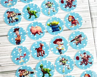 May include: A selection of circular stickers featuring characters from the Toy Story film series. Each sticker has a light blue background with white clouds and a different character illustration, including Woody, Buzz Lightyear, and Jessie.