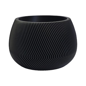 May include: A black, round planter with a wavy, textured design. The planter is made of a smooth, hard material.