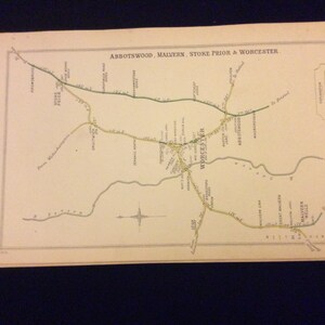 May include: A vintage map of the railway lines in the area of Worcester, Malvern, and Stoke Prior in England. The map is printed in black and green ink on a cream-colored paper. The map shows the railway lines, stations, and towns in the area. The map is titled "Abbotswood, Malvern, Stoke Prior & Worcester."