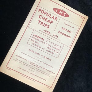 Può includere: Un opuscolo vintage in carta color crema con testo rosso che pubblicizza "Viaggi popolari economici" sulla ferrovia LMS nel giugno 1936. Il opuscolo elenca escursioni di mezza giornata da Liverpool a Edge Hill, Mossley Hill, Allerton, Fazakerley, Runcorn, Preston Road e Ormskirk.