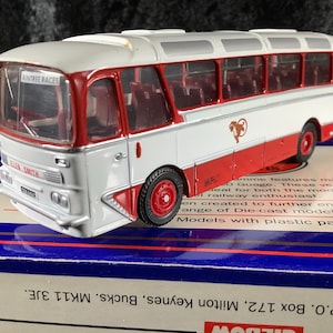 Puede incluir: Modelo de autobús rojo y blanco con la inscripción "Aintree Races". El autobús en miniatura tiene ruedas y adornos rojos. La escala es 1:76. Un objeto de colección.