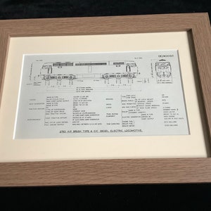 Puede incluir: Impresión enmarcada de un diagrama de la locomotora diésel-eléctrica 2750 HP Brush Tipo 4 CC. El diagrama es en blanco y negro, con especificaciones técnicas y medidas detalladas. El marco es de color marrón claro.