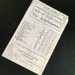May include: A vintage train ticket for travel to London on the S.E. & C.R. railway, dated June 14th. The ticket, printed on aged paper, lists stations, times, and fares. The text includes "Cheap Day Return Tickets".