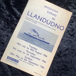 May include: Vintage excursion ticket to Llandudno, featuring a blue and white steam packet ship illustration. The ticket, issued by British Rail, lists dates from May to September 1966. Text includes "excursion tickets to Llandudno" and "Via Liverpool and the Isle of Man Steam Packet Company Steamers."