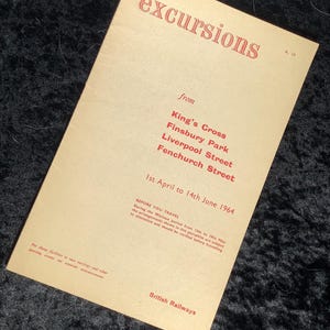 Pode incluir: Um folheto de excursões vintage da British Railways. O papel creme apresenta texto vermelho, incluindo a palavra "excursions" no topo e uma lista de estações de trem. O período do folheto é de 1º de abril a 14 de junho de 1964.