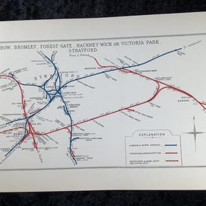 May include: A vintage map print featuring a detailed railway network around Stratford, Bow, and Hackney Wick. The map uses blue and red lines to depict routes, with place names clearly labeled. The title reads "BOW, BROMLEY, FOREST GATE, HACKNEY WICK OR VICTORIA PARK STRATFORD."