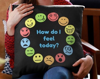 May include: Black throw pillow with a circle of colorful smiley faces and the text "How do I feel today?" in blue.