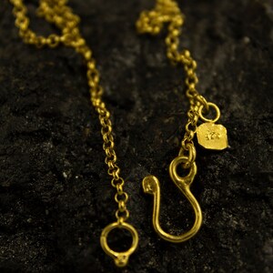 Puede incluir: Un collar de cadena de oro con un cierre de langosta y una peque&ntilde;a etiqueta con el n&uacute;mero "925".