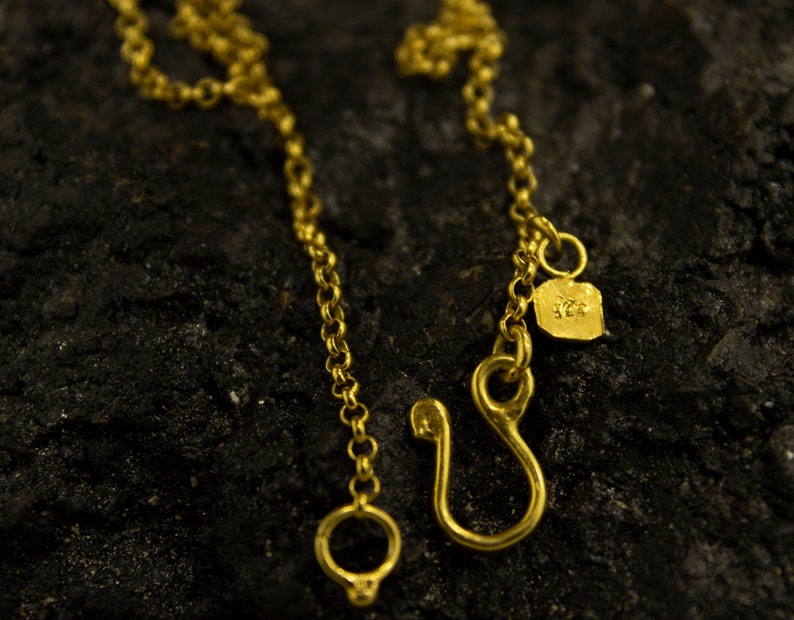 Puede incluir: Un collar de cadena de oro con un cierre de langosta y una peque&ntilde;a etiqueta con el n&uacute;mero "925".