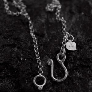 Puede incluir: Un collar de cadena de plata con cierre de gancho y una peque&ntilde;a etiqueta que dice "925".