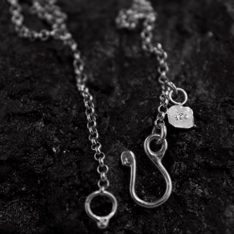 Puede incluir: Un collar de cadena de plata con cierre de gancho y una peque&ntilde;a etiqueta que dice "925".