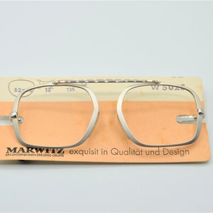 Puede incluir: Gafas de lectura plateadas con un puente texturizado y una etiqueta que dice "MARWITZ exquisit in Qualit&auml;t und Design EIN UNTERNEHMEN DER ZEISS-GRUPPE"