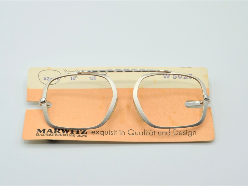 Puede incluir: Gafas de lectura plateadas con un puente texturizado y una etiqueta que dice "MARWITZ exquisit in Qualit&auml;t und Design EIN UNTERNEHMEN DER ZEISS-GRUPPE"