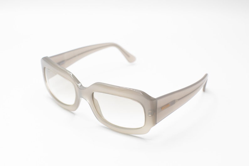 May include: A pair of light gray rectangular-shaped eyeglasses with clear lenses.