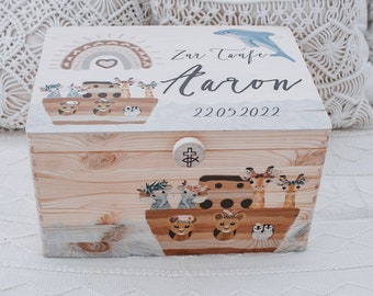 Könnte beinhalten: Eine hölzerne Erinnerungsbox mit einem weißen Deckel, auf dem ein Regenbogen, ein Herz und Tiere auf einem Boot zu sehen sind. Der Deckel trägt außerdem den Text "Zur Taufe Aaron 22.05.2022".