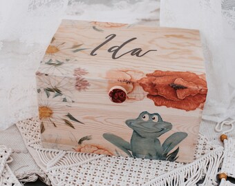 May include: A wooden box with a floral design and a frog illustration. The box has a red knob and is labelled "Ida".